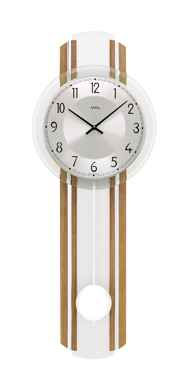 Wanduhr mit weißem Zifferblatt, geölten Eichenholzstreifen und Pendelwerk hinter Mineralglas.