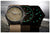 Zwei Armbanduhren nebeneinander, braune Stoffarmbänder, Ziffern mit grüner Leuchtwirkung