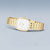 Damenuhr mit goldenem Metallarmband, rund-ovales Gehäuse und weißem Zifferblatt.
