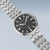Herrenarmbanduhr mit schwarzem, strukturiertem Zifferblatt und silbernem Metallband