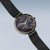 Damenuhr mit rundem dunklem Zifferblatt und goldenen Zeigern, Milanaise-Armband