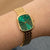 Damenuhr am Handgelenk mit grünem Zifferblatt und goldfarbenem Gliederarmband