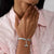 Snoopy-Anhänger am Armband: silbernes Charm-Detail mit blauem Roller am Handgelenk