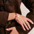 Textilarmband aus rotem Band mit silbernem Karabinerverschluss und kleinem Anhänger