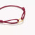 Rotes Textilarmband mit goldfarbenem Connect-Verschluss, Nahansicht der Öse