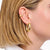 Goldener Earcuff am Ohr, geschwungene Form; daneben goldene Creole
