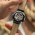 Herrenuhr Rückseite mit Glasboden, schwarzes Lederarmband und gelbe Bandakzente