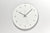 Runde Wanduhr mit weißem Zifferblatt, Zahlen 12–6 und drei Zeigern