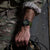 Herrenarmbanduhr am Handgelenk einer Person im Tarnmuster, olivfarbenes Armband und leuchtende Anzeigen