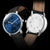 Herrenuhr: blaue Front und Rückseite mit Kreisgravur, braunes Lederarmband.