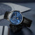 Herrenuhr im Winkel: blaues Zifferblatt, schwarzes Lederarmband.