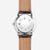 Sternglas Herrenuhr Rückseite mit Kreisdesign im silberfarbenen Gehäuse, braunes Lederband.