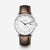 Uhr mit dunkelbraunem Lederarmband, rundem silbernem Gehäuse und weißem Zifferblatt.