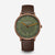 Unisex-Uhr mit rundem Gehäuse, grünem Zifferblatt und braunem Lederarmband.