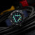 Herrenuhr Detailansicht: rundes Gehäuse mit Leuchtziffern und blauem Textilband