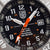 Herrenuhr-Zifferblatt: schwarze Skala mit Ziffern, orange Zeiger, Datumsfenster, LUMI NOX Logo im Zentrum