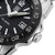 Herrenuhr im Detail: schwarzes Zifferblatt, silberner Gehäuserand und Krone bei 3 Uhr