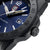 Detailansicht: blaue Taucheruhr mit Krone, geriffelter Lünette und schwarzem Armband