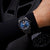 Herrenuhr am Handgelenk mit blauem Zifferblatt, dunklem Gehäuse und Silikonband
