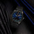 Herrenuhr am Handgelenk mit blauem Zifferblatt und leuchtenden Markierungen