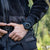 An der Hand getragene Sportuhr mit schwarzem Armband und dunklem Zifferblatt.