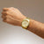 Herrenuhr am Handgelenk, goldfarbenes Edelstahlarmband und silbern-gelbes Zifferblatt