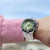 Edelstahl-Herrenuhr am Handgelenk mit grünem Zifferblatt und schwarzer Lünette