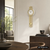 Wanduhr in Goldfarben mit rundem Ziffernblatt und pendelndem Gewichtsball
