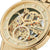 Goldene Herrenuhr mit Skelettzifferblatt, Indexen am Gehäuserand