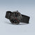 Bering-Armbanduhr Vorderansicht mit schwarzem Zifferblatt, roten Markierungen und dunklem Band
