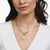 Collier mit goldfarbener Kette, Perlen und rundem Anhänger am Hals