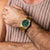 Herren-Armbanduhr am Handgelenk: grünes Malachit-Zifferblatt, goldfarbenes Metallgliederarmband