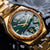 Herren-Armbanduhr mit grünem Malachit-Zifferblatt, goldfarbenes Armband und Holzlünette im Detail