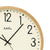 Wanduhr mit beigem Ziffernblatt, schwarzen Zeigern und hellem Holzrahmen, AMS.
