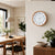 Wanduhr mit Holzoptik-Rahmen und weißem Ziffernblatt an der Wand