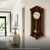 Holz-Wanduhr mit Glasfront, goldenem Pendel und römischen Ziffern im Zifferblatt