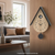 Wanduhr im Kuckucksstil mit Holzoptik und schwarzem Dach und Pendelgewicht