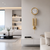 Messing-Wanduhr mit rundem Zifferblatt und langen goldenen Kettenpendeln an der Wand