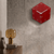Rote Würfel-Wanduhr aus Acryl an der Wand mit weißen Zeigern und Hermle-Logo