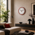 Wanduhr an der Wand mit rotem Rand über Couch und Sideboard