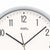 Nahaufnahme Wanduhr-Zifferblatt mit Ziffern 11–12 und Zeigern, silberner Außenring