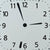 Nahaufnahme der weißen Funk-Wanduhr: schwarze Zeiger, Punkte als Minutenmarken, Ziffern 1–12.