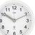 Nahaufnahme: weiße runde AMS Wanduhr mit schwarzen Ziffern, Zeigern und Logo
