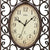 Antike Wanduhr, Nahaufnahme: Ziffernblatt mit römischen Ziffern und Metallornamentrahmen