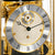 Tischuhr-Ziffernblatt im Detail: römische Zahlen, goldene Mechanik, unter Glaskuppel