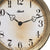 Detail der Wanduhr: messingfarbener Rahmen, Ziffern und schwarze Zeiger, Hermle