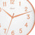 Detailansicht der Wanduhr: weißes Zifferblatt mit orangefarbenen Ziffern, Zeigern und Hermle-Schriftzug